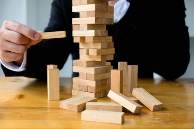 Man playing with stuffed toy on wooden table