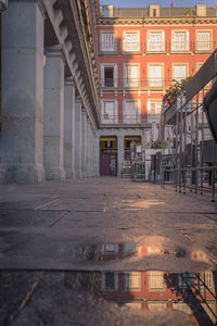 Illuminated street amidst buildings in city