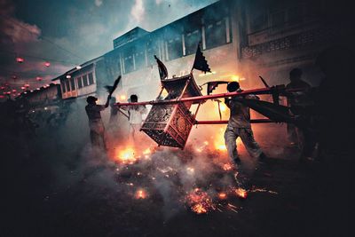 Men performing during festival on street at dusk