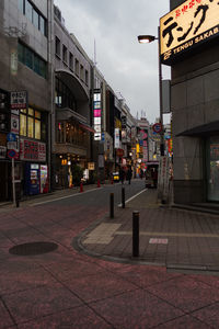 Illuminated city street and buildings against sky