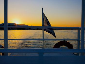 Boat sailing on sea against clear sky during sunset