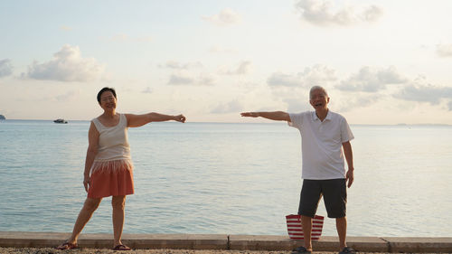 Full length of man standing on sea against sky