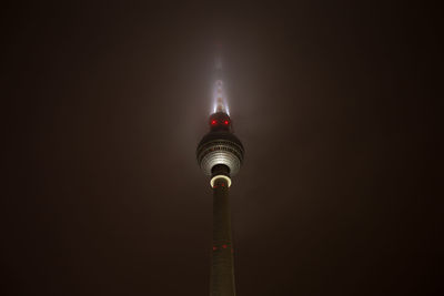 Low angle view of illuminated tower against sky at night