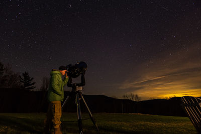 Man photographing against sky at night