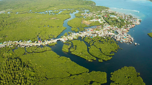 City in wetlands and mangroves on the ocean coastline aerial view. siargao island, philippines.