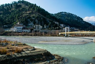 Scenic view of river by mountains against sky