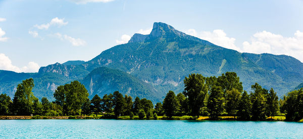 Scenic view of lake by trees against sky