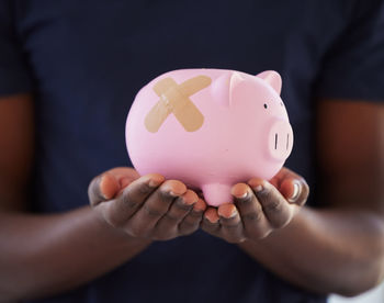 Midsection of woman holding piggy bank