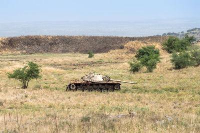 Side view of abandoned vehicle on field