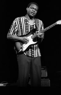 Full length portrait of young man standing against black background