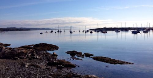 Sailboats in sea against sky