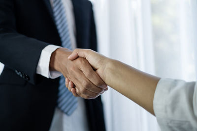 Midsection of business colleagues shaking hands