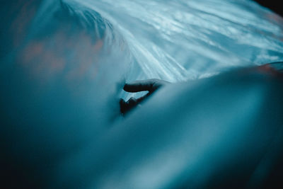 Midsection of person relaxing in sea