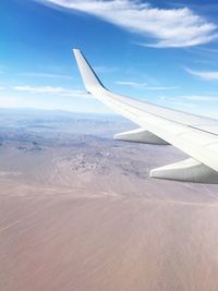 Airplane flying over landscape against sky