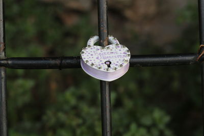 Close-up of heart shape hanging on metal chain