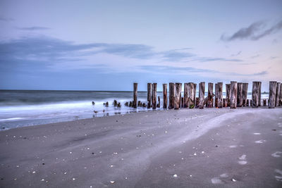 Dawn over a dilapidated pier on the beach in port royal in naples, florida.