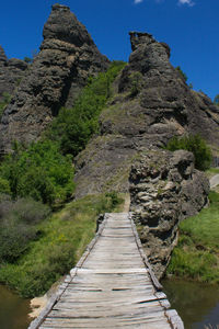 Footpath leading towards mountain against clear sky