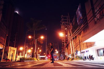 Man walking on illuminated road at night