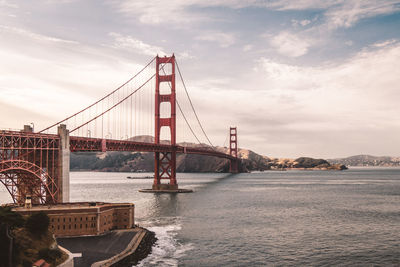 View of suspension bridge against cloudy sky