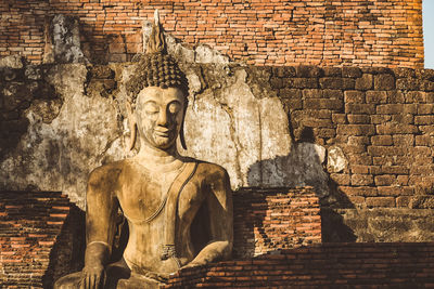 Statue against brick wall