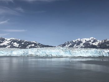 Scenic view of snowcapped mountains by sea against sky