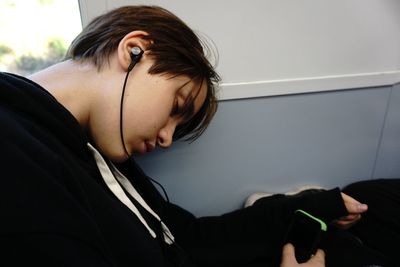Solo traveler asleep on the bus with earphones