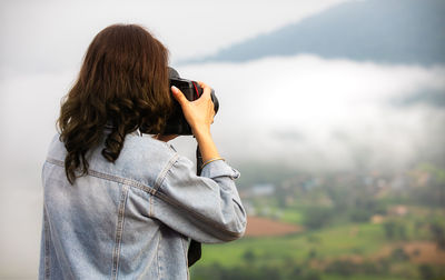 Midsection of woman photographing outdoors