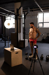 Muscular sportsman preparing for remote fitness training