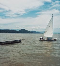 Sailboat sailing on sea against sky