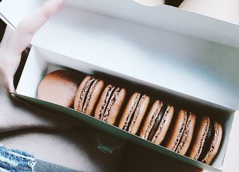 Midsection of person holding box with macaroons