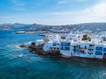 Scenic view of sea by buildings against sky