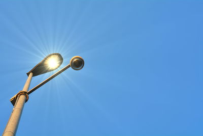 Low angle view of illuminated street light against sky