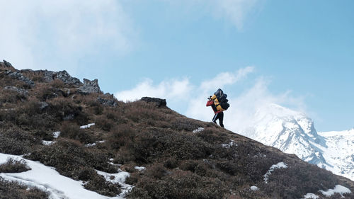 Man skiing on snowcapped mountain against sky