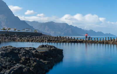 Scenic view of sea and mountains against sky