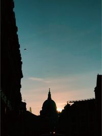 Low angle view of silhouette buildings against sky