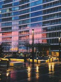 Illuminated buildings by street in city at night