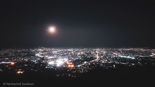 Illuminated cityscape against sky at night