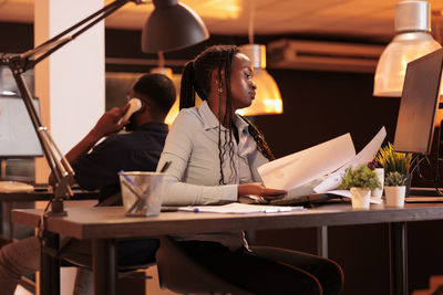 Young woman doing paperwork at office