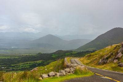 Scenic view of road amidst mountains against sky