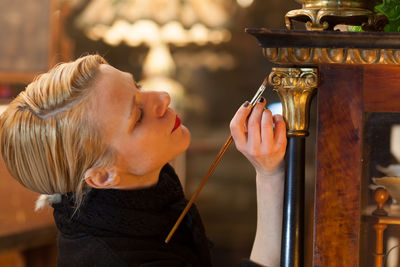 Close-up of mature woman painting furniture