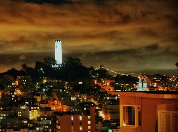 Illuminated cityscape against sky at night