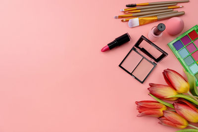 Directly above shot of beauty products on pink background