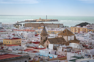 High angle view of townscape by sea against sky