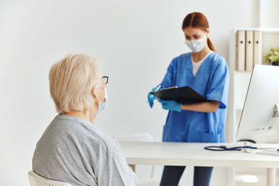 Young woman using phone while standing on table