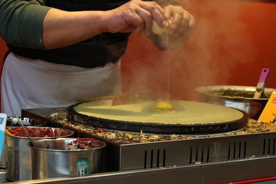 Midsection of man preparing food in kitchen