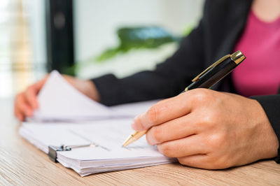 Close-up of man hand holding paper on table