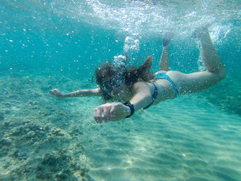 Girl swimming under the sardinian's sea