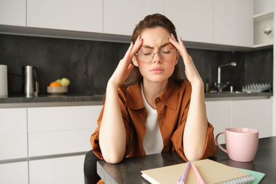 Portrait of young woman using laptop at home