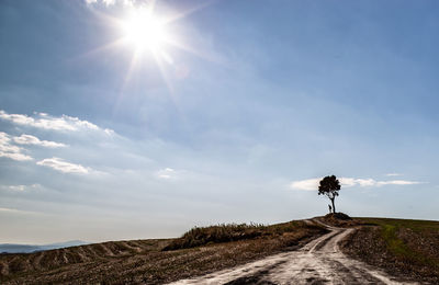 Road amidst land against sky