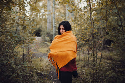 Woman standing in forest during autumn